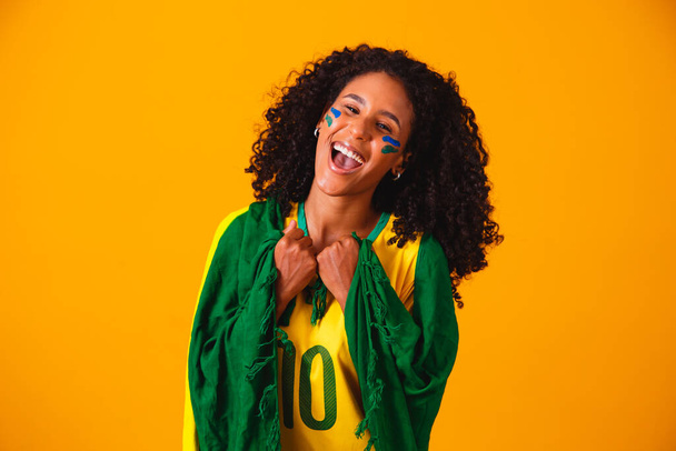 Brazilian fan. wearing Brazilian flag in a portrait, Brazilian fan celebrating football or soccer game on yellow background. Colors of Brazil.World Cup - Foto, imagen