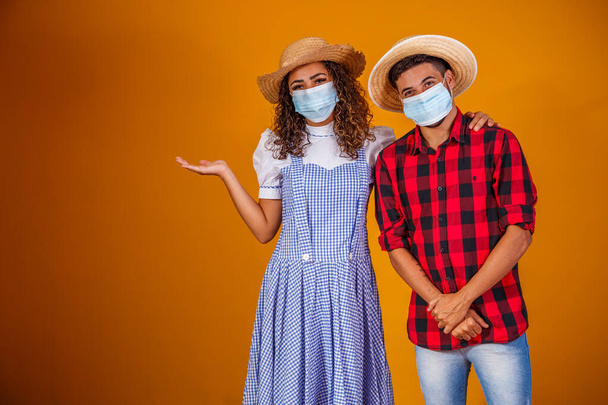 couple wearing typical clothes for the Festa Junina (Junina Party) and protection mask to prevent COVID-19. - 写真・画像