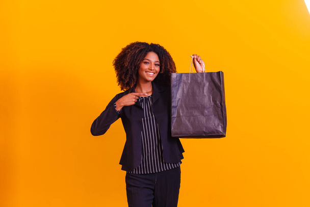 Afro executive woman with black shopping bag. Blackfriday concept - Foto, imagen