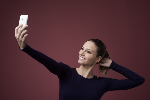 Smiling woman taking a selfie - Фото, изображение