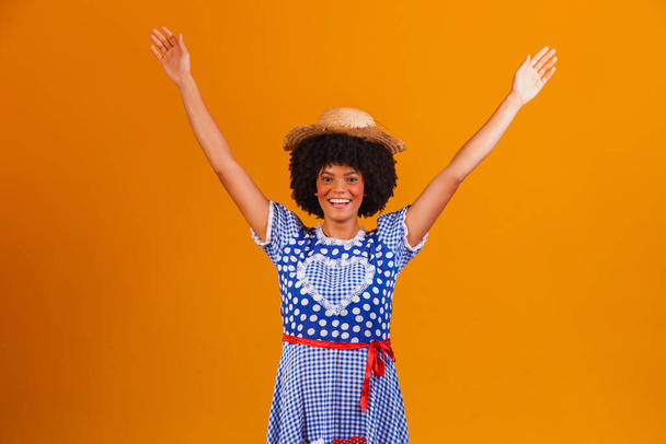 Brazilian afro woman wearing typical clothes for the Festa Junina in yellow background - Fotografie, Obrázek