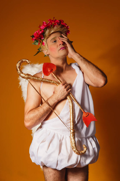 Valentine's day concept. Portrait of the God of love - Cupid with bow and arrow on a yellow background. - Foto, immagini