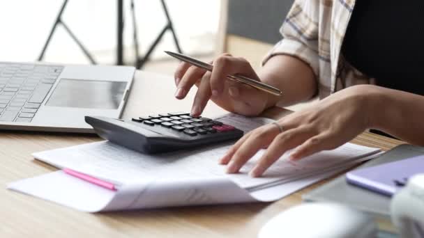 Lähellä käsi nainen käyttää laskin laskea tarkistaa laskuja, verot, pankkitilin saldo ja laskemalla kulut olohuoneessa kotona.. - Materiaali, video