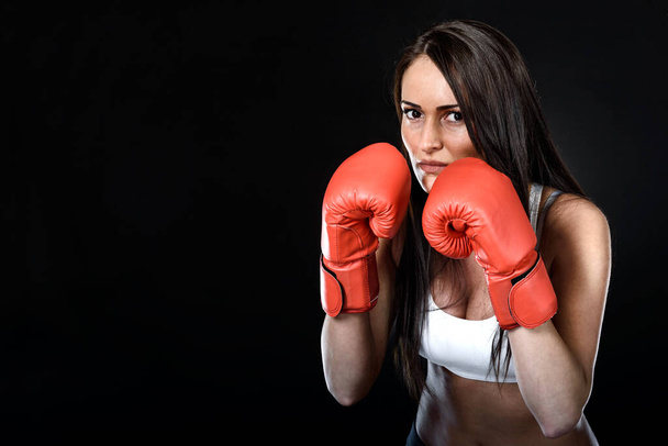 young woman with red boxing gloves on black background - Photo, Image