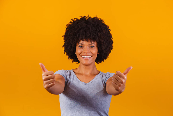 Portrait of smiling beautiful young afro girl thumbs up. Brazilian girl. - Photo, Image