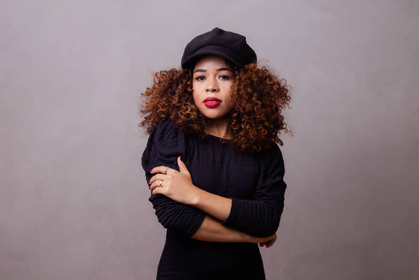 Afro woman with curly hair wearing beret and warm clothes. - Fotografie, Obrázek