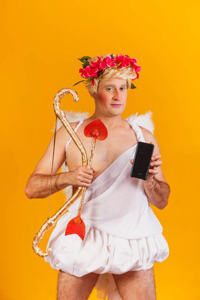 cupid holding cell phone. Valentine's Day promotion - Foto, afbeelding