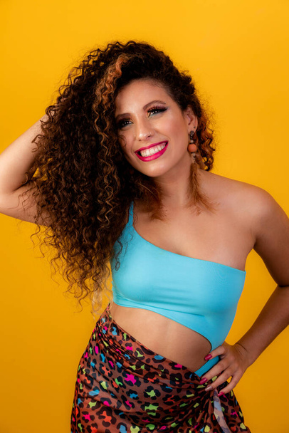 Beauty portrait of african american woman with afro hairstyle and glamour makeup. Brazilian woman. Mixed race. Curly hair. Hair style. Yellow background. Afro woman smiling at the camera - Foto, Imagen