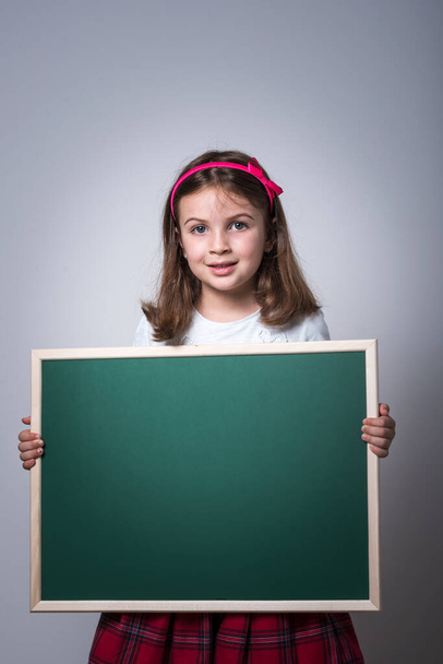 Little School Girl Holding Green School Board - Foto, Imagen