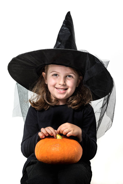 dziewczynka w strój czarownicy gospodarstwa halloween dyni   - Zdjęcie, obraz