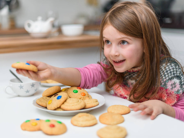 smiling little girl with cookies  - Фото, зображення