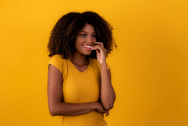 Nervous afro woman on yellow background - Foto, Imagen