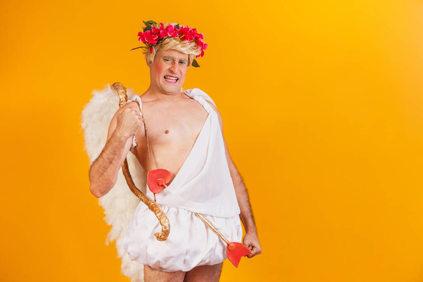 Valentine's day concept. Portrait of the God of love - Cupid with bow and arrow on a yellow background. - Φωτογραφία, εικόνα