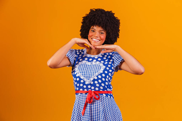 Brazilian afro woman wearing typical clothes for the Festa Junina in yellow background - Foto, immagini