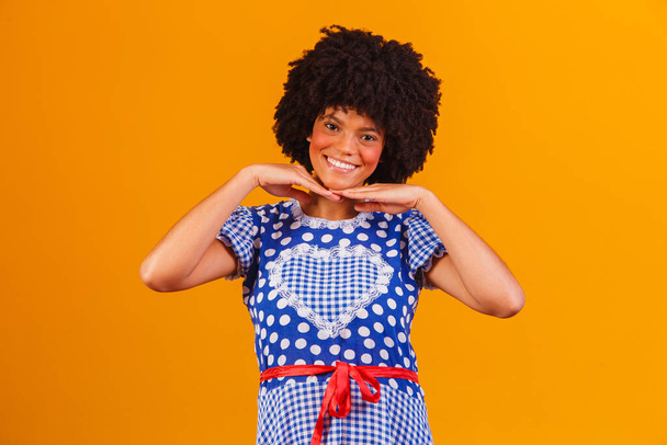 Brazilian afro woman wearing typical clothes for the Festa Junina in yellow background - Foto, imagen