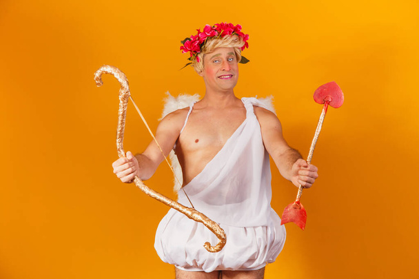 Valentine's day concept. Portrait of the God of love - Cupid with bow and arrow on a yellow background. - Valokuva, kuva
