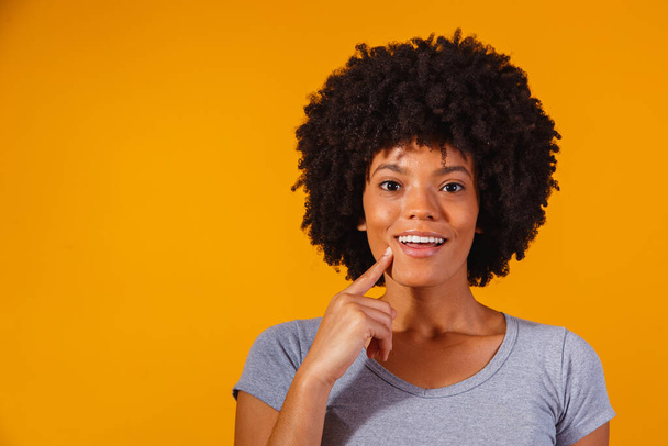 afro woman thinking on yellow background with space for text - Фото, изображение