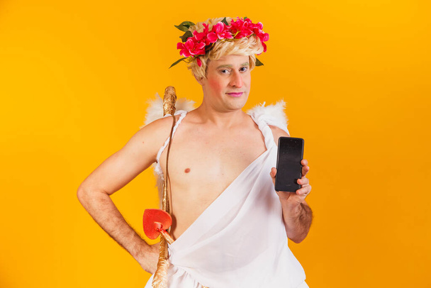 cupid holding cell phone. Valentine's Day promotion - Foto, Imagen