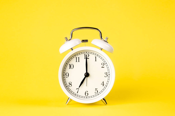White alarm clock on a yellow background isolated, close-up. Minimal creative concept. - Foto, immagini