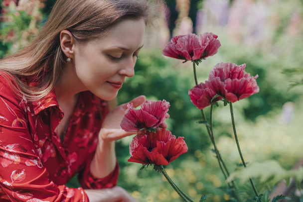 Portrait of young beautiful woman with poppies in the garden - Photo, Image