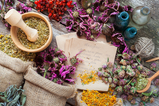 Healing herbs in hessian bags, wooden mortar, bottles with tinct - Foto, imagen