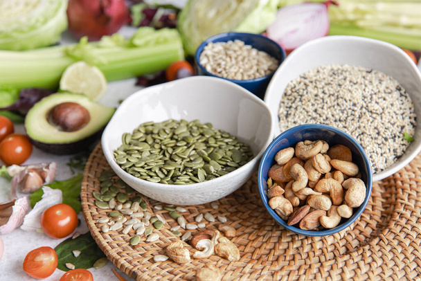 Semillas de calabaza, frutos secos y semillas de chía y verduras saludables en la mesa de la cocina, concepto de alimentación saludable. - Foto, Imagen