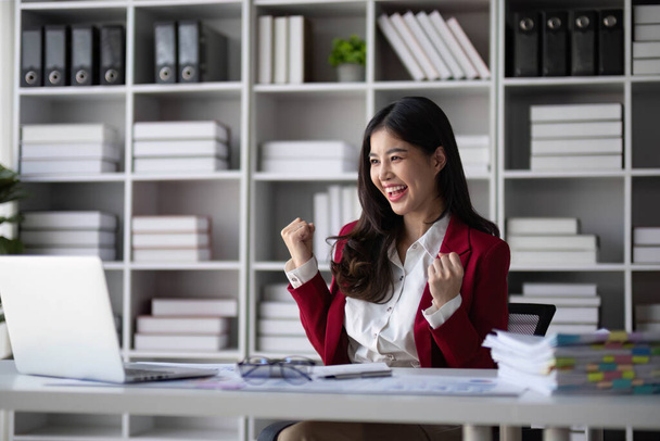 Aziatische bedrijven zijn enthousiast over het vieren van zakelijk succes met inspiratie uit hun uitstekende financiële resultaten die gelukkig zijn met het werken in een modern kantoor - Foto, afbeelding