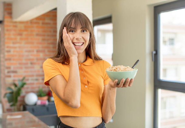 young pretty woman feeling happy and astonished at something unbelievable. breakfast bowl concept - Foto, Imagem