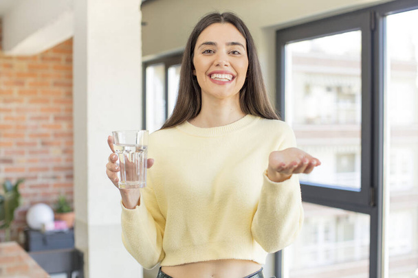 pretty young model smiling happily and offering or showing a concept. water glass concept - Fotoğraf, Görsel