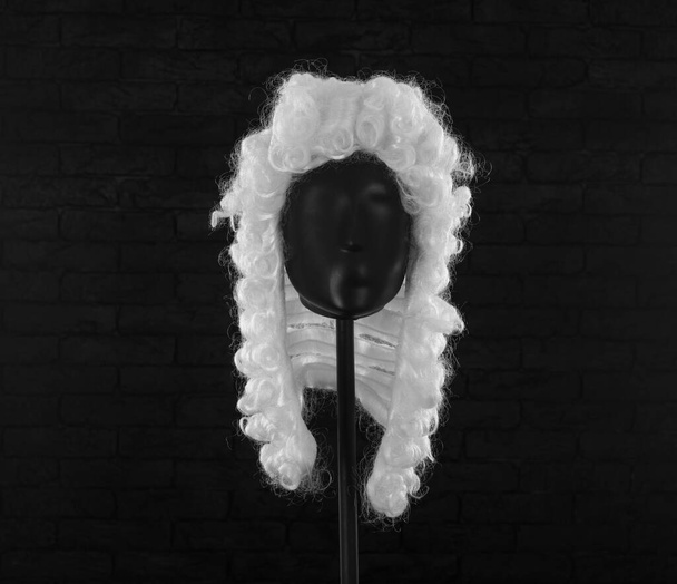 parrucca avvocato bianco su un manichino su uno sfondo nero - Foto, immagini