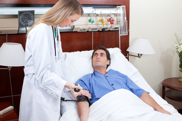 Doctor checking blood pressure of patient - Φωτογραφία, εικόνα