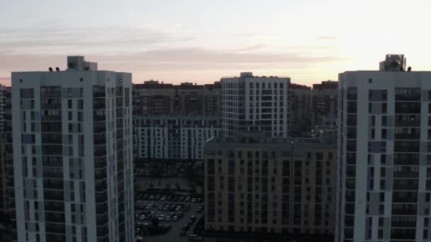 日没の美しい都市エリアのトップビュー. ストック映像。 太陽の日没の光で都市の近代的なエリアの住宅の高層ビル. 建物が建っている住宅街の美しいパノラマ - 映像、動画