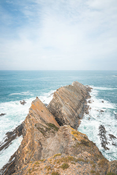 Widok na skaliste wychodnie wznoszące się z Oceanu Atlantyckiego w Zambujeira do Mar, region Odemira, zachodnia Portugalia. Wędrując wzdłuż szlaku rybackiego, Rota Vicentina. - Zdjęcie, obraz