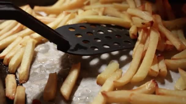 Gros plan d'agiter la friture de pommes de terre frites sur une plaque de cuisson au four. Cuisine à la maison ou au restaurant. Restauration rapide, mauvaise alimentation. - Séquence, vidéo