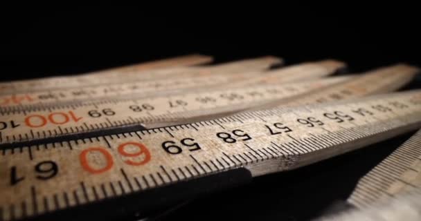 Construction folding wooden measuring tool. Folding carpenters ruler on black background - Footage, Video