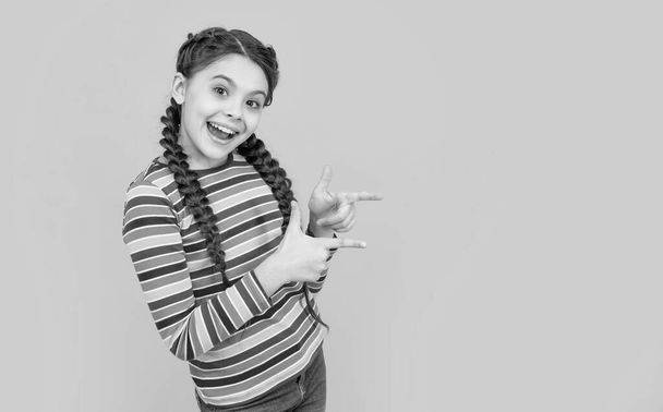 teen girl with braids on hair in studio with copy space. photo of teen girl having braids. childhood studio shot of teen girl has braids. teen girl with braids isolated on yellow background. - Foto, Imagen