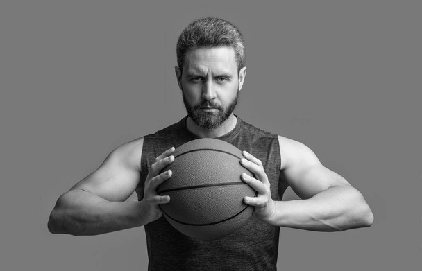 muscular athlete man basketball player with ball. athlete man basketball player in sportswear. athlete man basketball player isolated on grey background. athlete man basketball player in studio. - Foto, imagen
