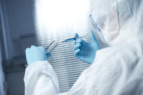 Researcher preparing a syringe for injection - Фото, изображение