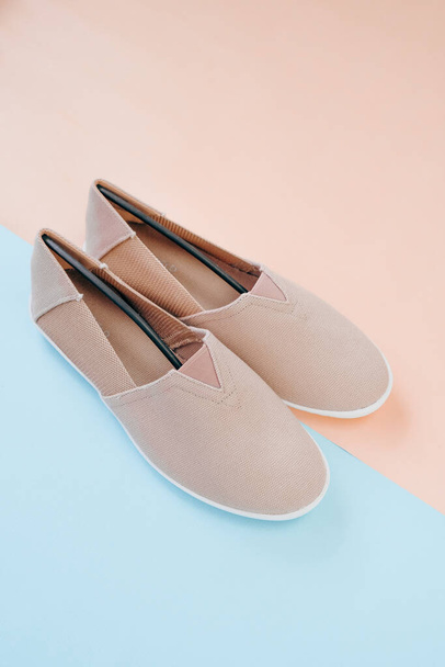 Béžová tkanina espadrilles boty pár na béžové modré kombinované pozadí.Letní světlo pohodlné boty ve světle béžové odstíny.Módní obuv pro letní sezónu - Fotografie, Obrázek