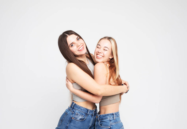 lifestyle and people concept: Two young female friends standing together and having fun. Looking at camera. - Foto, immagini