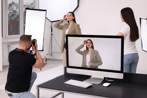 Professional photographer and assistant working with beautiful model in modern photo studio, selective focus - Fotografie, Obrázek