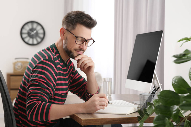 Man studying near computer at home. Online translation course - Foto, Imagem