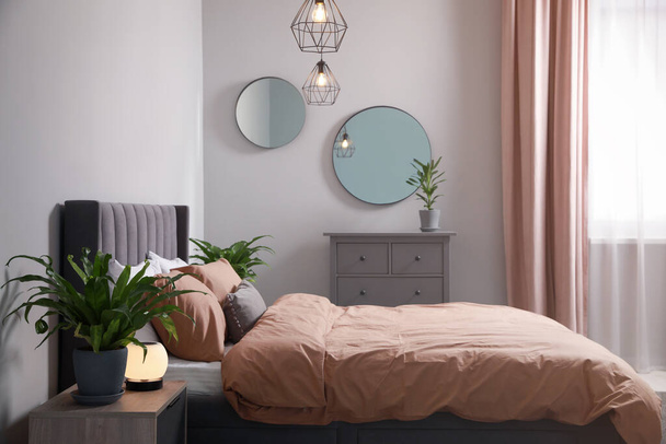 Stylish bedroom interior with comfortable bed and green houseplants - Φωτογραφία, εικόνα