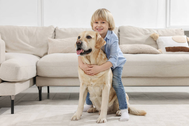 Cute little child with Golden Retriever at home. Adorable pet - Foto, immagini
