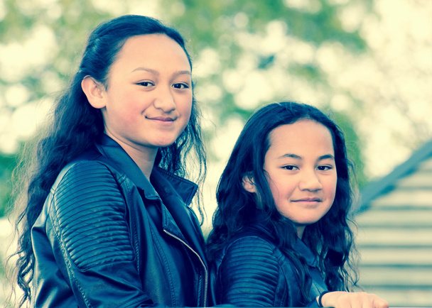 Retrato de dos jóvenes hermanas maoríes tomadas al aire libre en un parque. - Foto, imagen