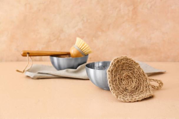 Bowl and natural household sponge on beige background - Фото, зображення