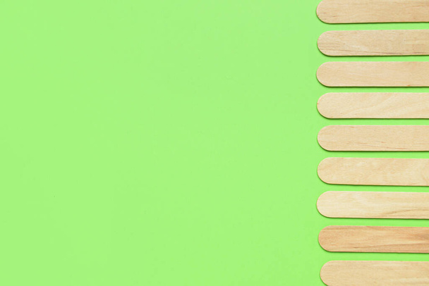 Ice cream sticks on green background - Foto, afbeelding