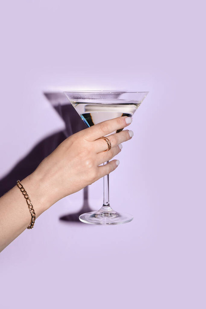 Woman with glass of martini on lilac background - Фото, зображення