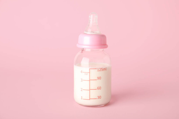 Bottle of milk for baby on pink background - Fotografie, Obrázek