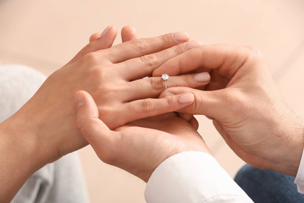 Hombre poniendo anillo de compromiso en el dedo de la mujer, primer plano - Foto, imagen